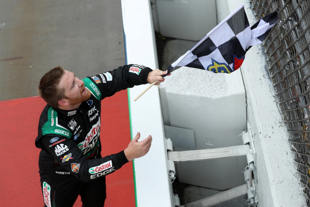 Chris Buescher, driver of the #17 car for RFK Racing, receives the checkered flag after winning the Cup Series race at Michigan International Speedway on August 7, 2023. The 2023 season was a breakout year for Buescher as well as the entire RFK Racing team.