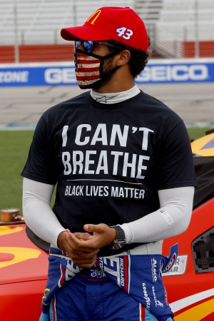 NASCAR Cup Series competitor Bubba Wallace wears a &quot;I Can&#039;t Breathe — Black Lives Matter&quot; T-shirt under his fire suit in solidarity with protesters around the world taking to the streets after the death of George Floyd, prior to the NASCAR Cup Series race at Atlanta Motor Speedway on June 7, 2020, in Hampton, Georgia.